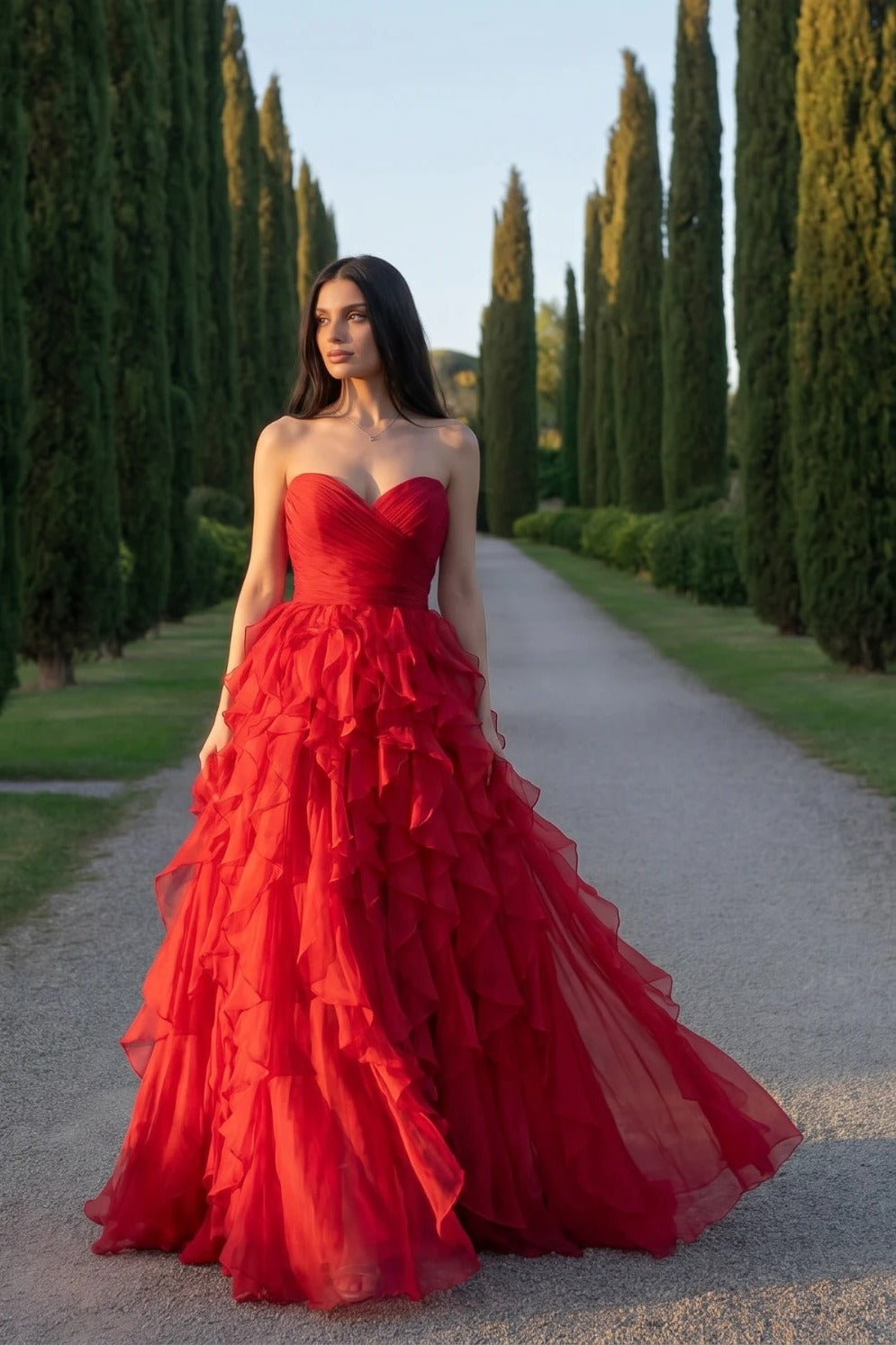 Rochia Ruffle Elegance roșie pe o alee cu chiparoși